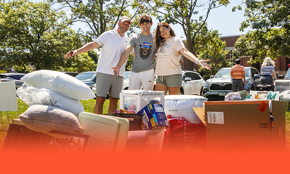 family poses with their student's stuff they're moving into the dorms during Welcome Week