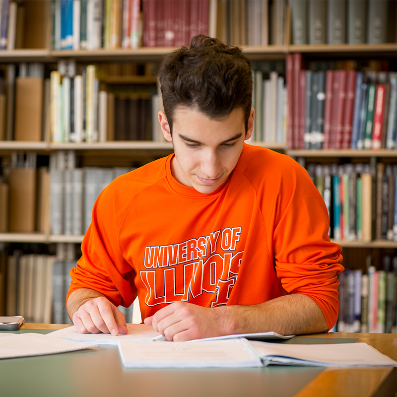 student reading a book in the library