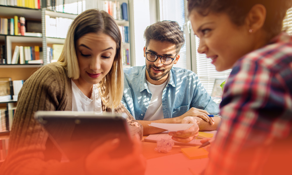 high school students looking at a tablet