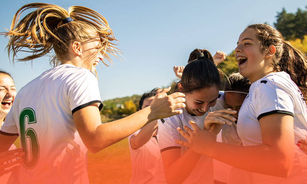 closeup of high school soccer team celebrating a win together