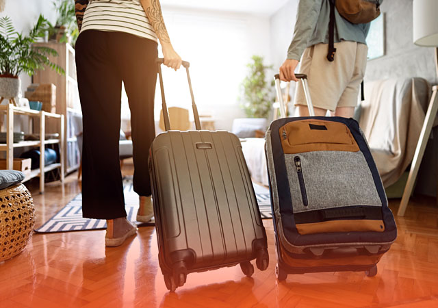 couple wheeling their luggage into a hotel room