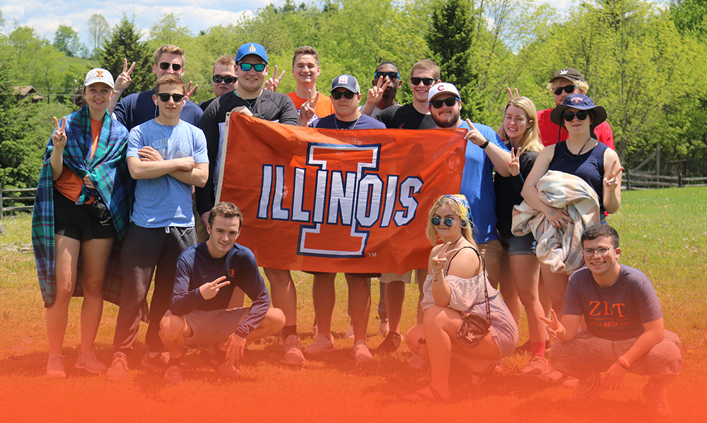 RST students posing with UIUC flag in the fields at Woodstock