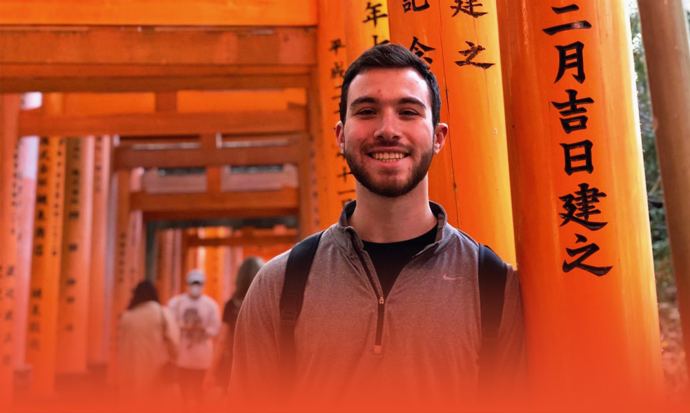Steven posing underneath the Torii at Fushimi Inari Temple in Kyoto, Japan
