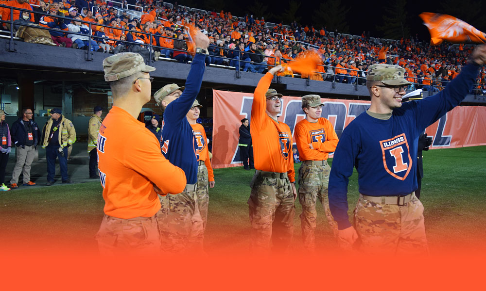 ROTC Pushup Crew celebrate a score on field at an Illinois football game