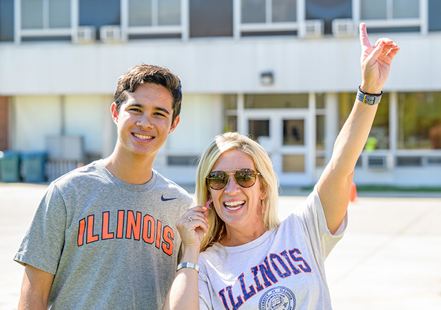 new illini posing with pround mom outside of weston