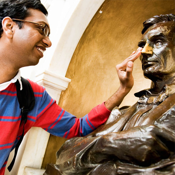 student rubbing Lincoln's nose