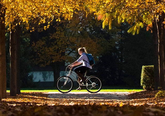 a student biking on campus